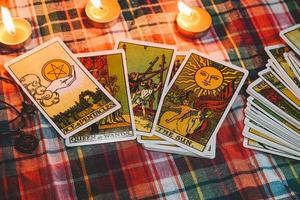 tarot reading with tarot card background and candlelight on the table for astrology occult magic spiritual horoscopes and palm reading fortune teller tarot reader free photo Bhakit